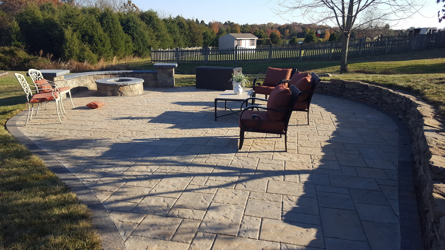 large back yard patio with retaining wall and fire pit