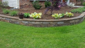 raised bed with stone wall and lush green lawn